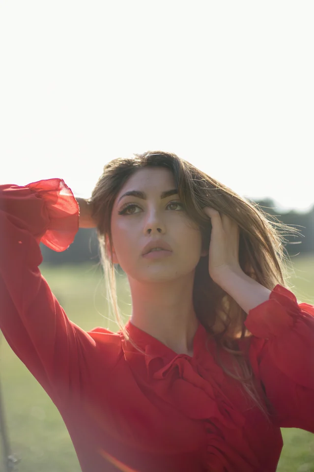 Ritratto editoriale in esterni con abito rosso e luce naturale