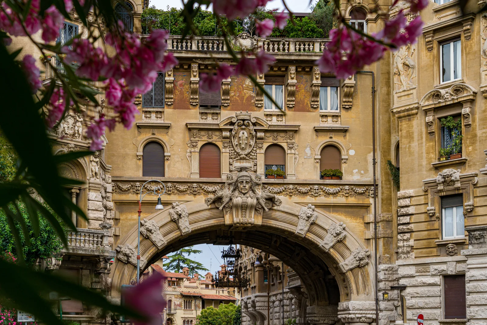 Ingresso ad arco di Coppedè incorniciato da fiori in primo piano