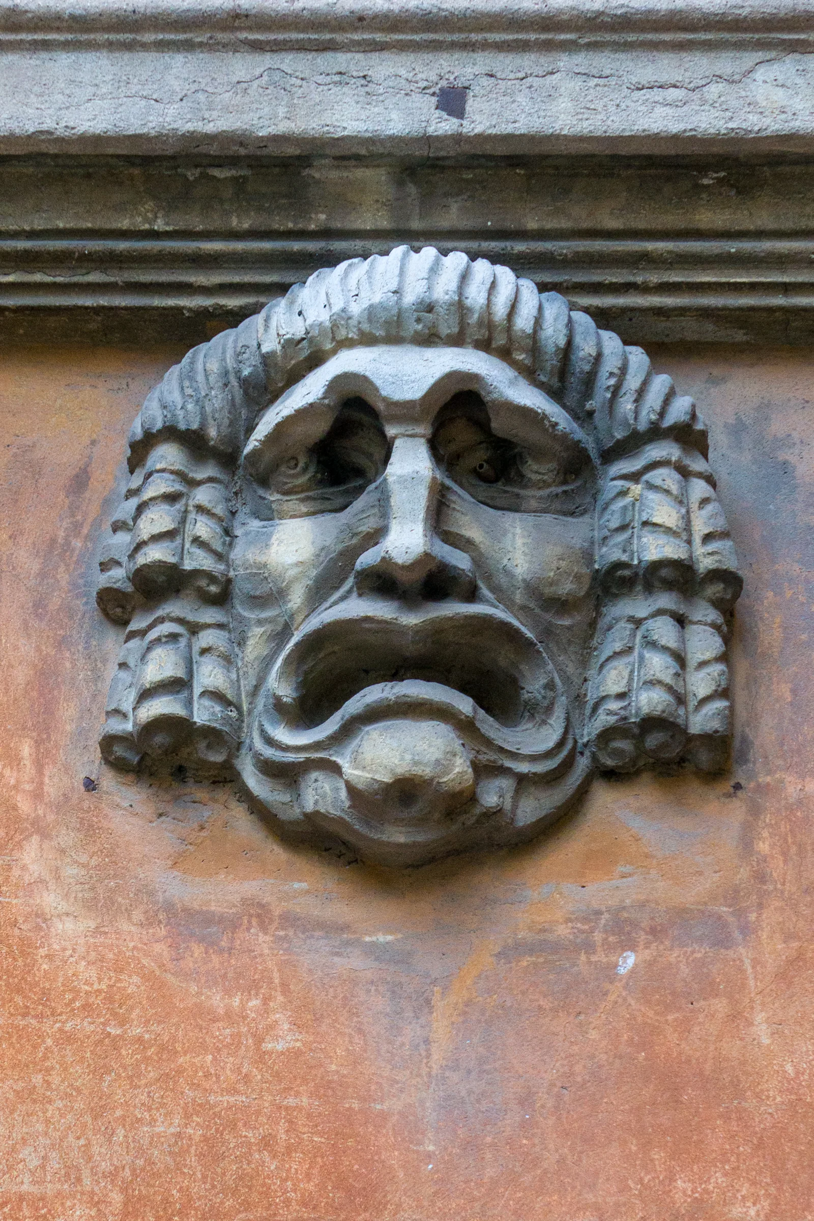 Maschera scolpita in pietra su una facciata del Quartiere Coppedè