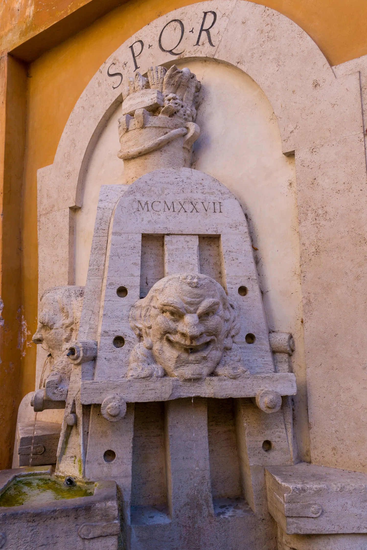 Fontanella monumentale incassata in una parete con stemma SPQR