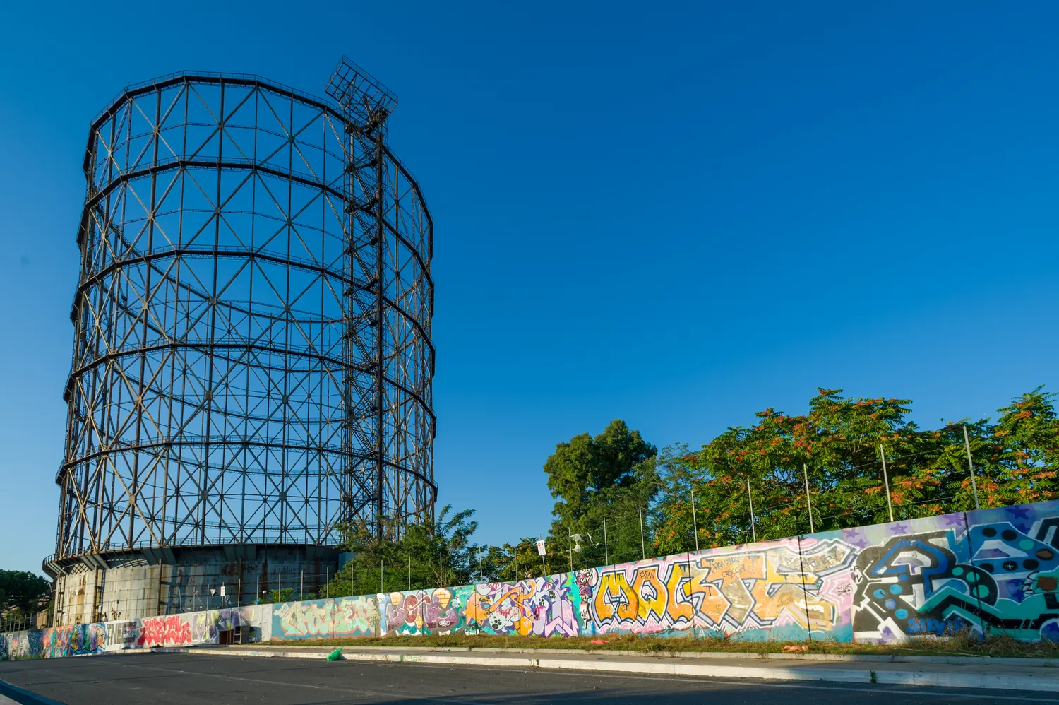Gazometro di Roma ripreso dal basso con cielo blu e street art