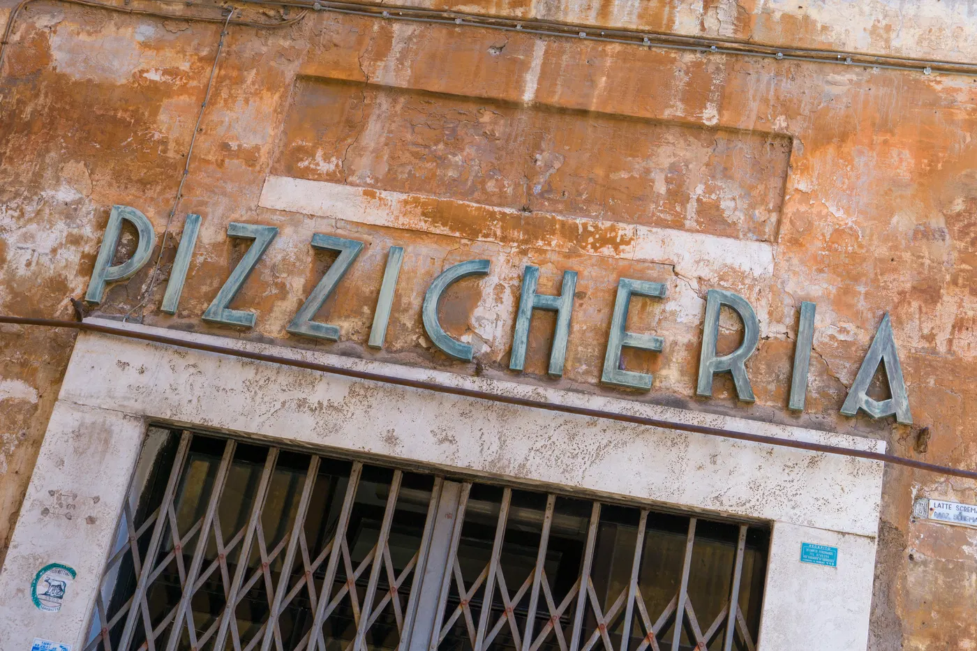 Vecchia insegna Pizzicheria su facciata romana