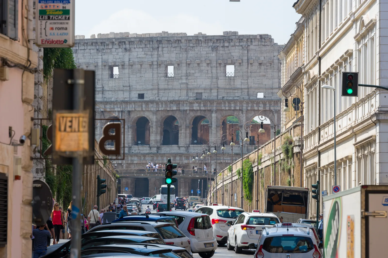 Colosseo visto in fondo a una strada del Rione Monti con il traffico