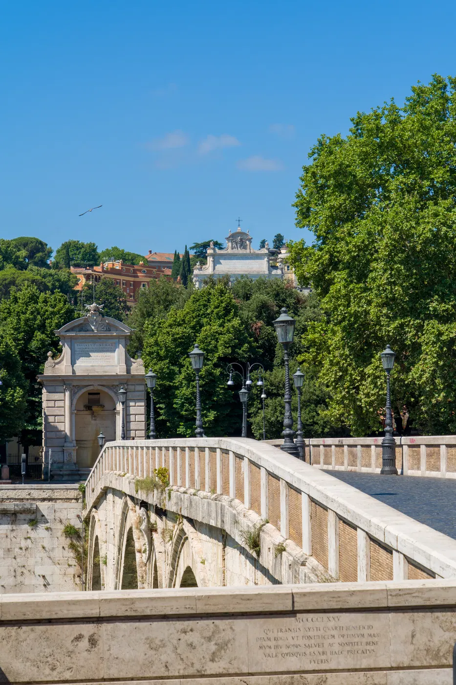 Ponte storico di Roma ripreso lungo il parapetto con alberi e fiume