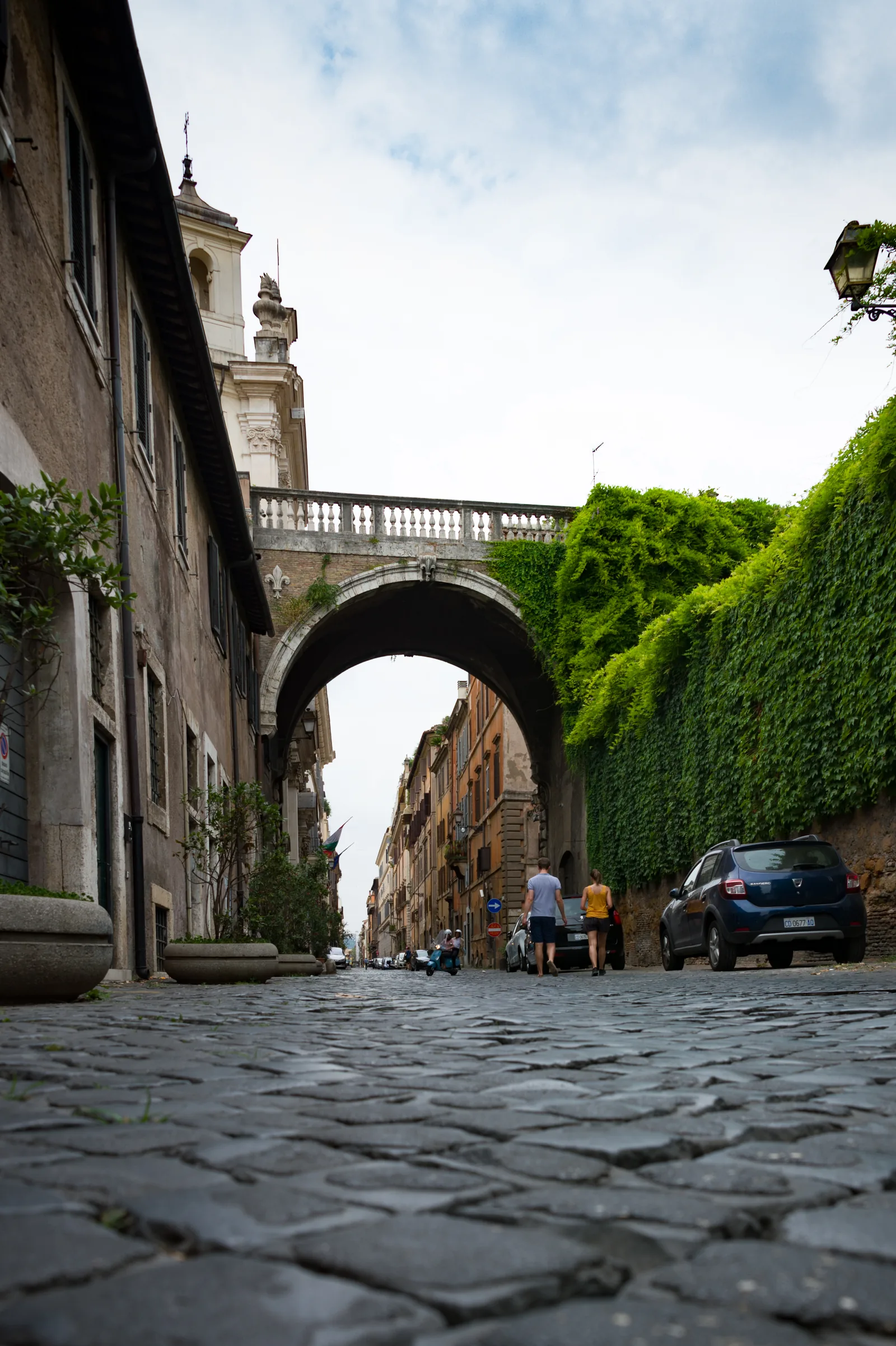 Arco in pietra sopra una strada lastricata di Roma