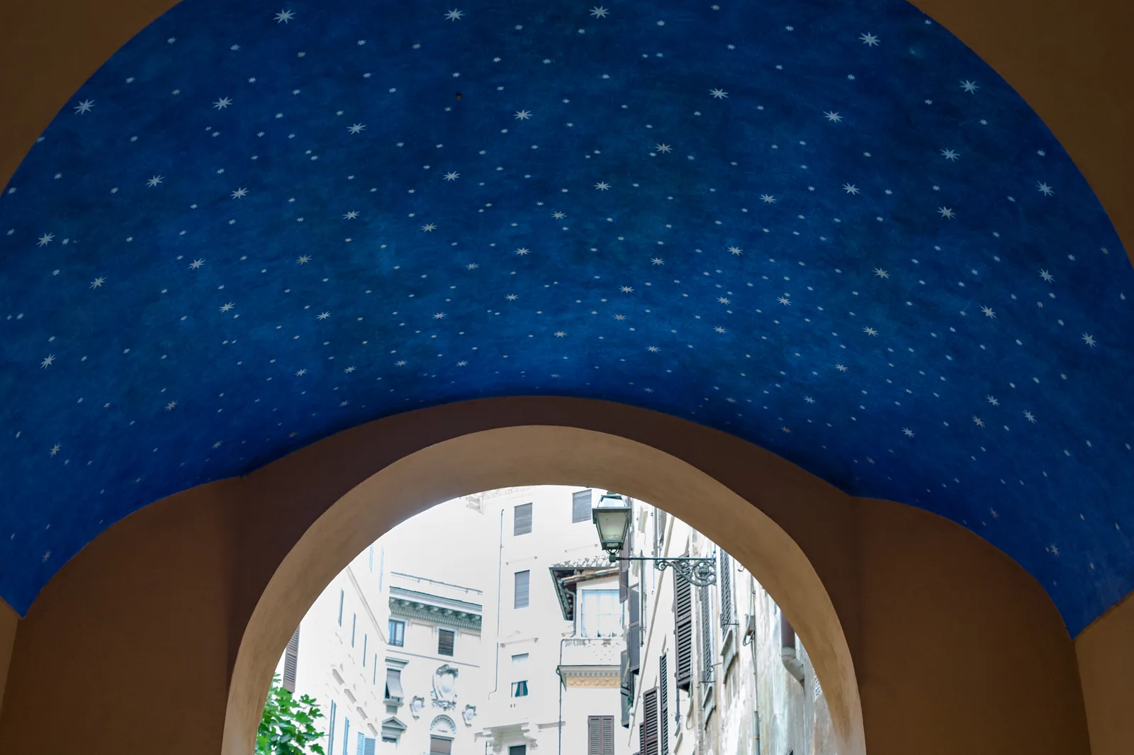 Passaggio ad arco con volta blu stellata e strada visibile sullo sfondo