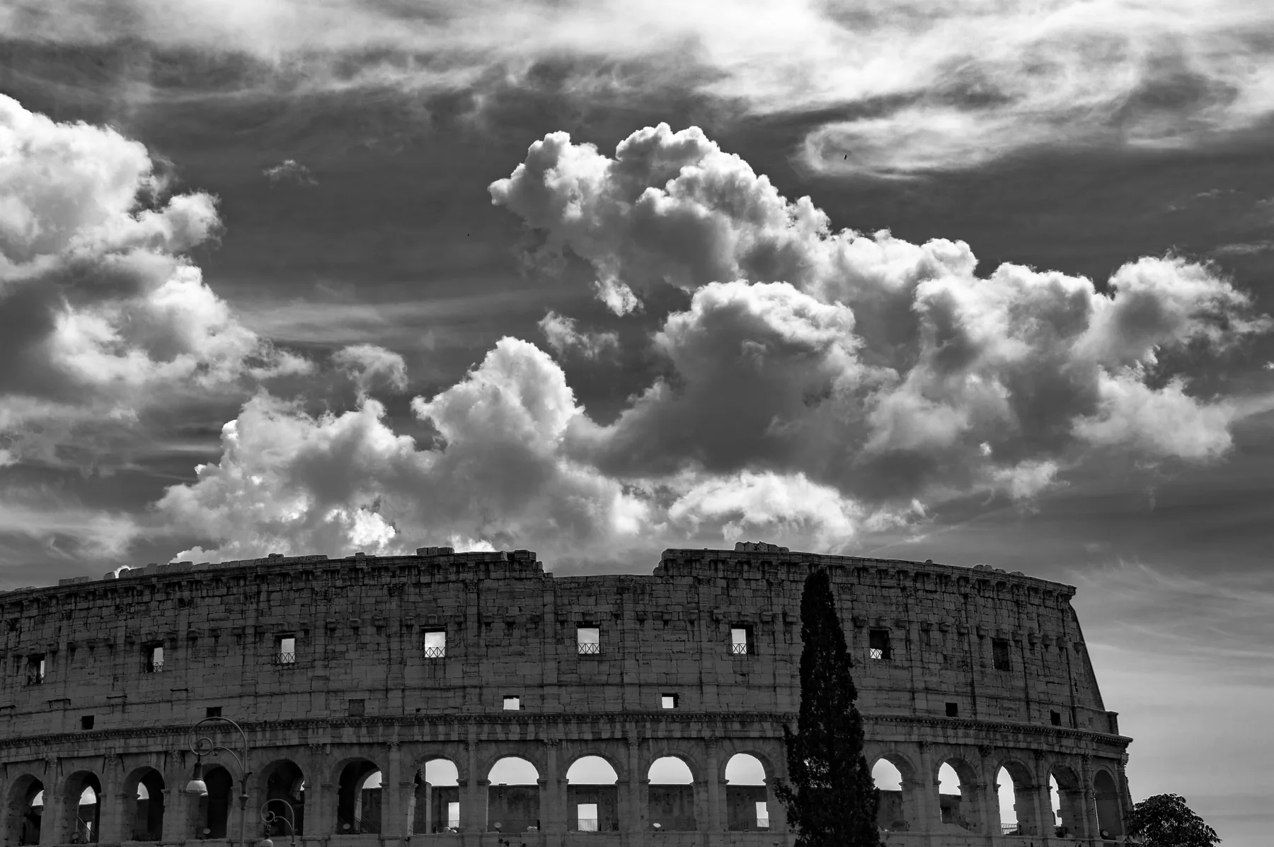 Colosseo in bianco e nero sotto un cielo drammatico