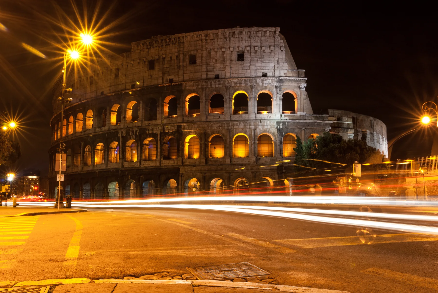 Colosseo di notte fotografato con scie luminose del traffico