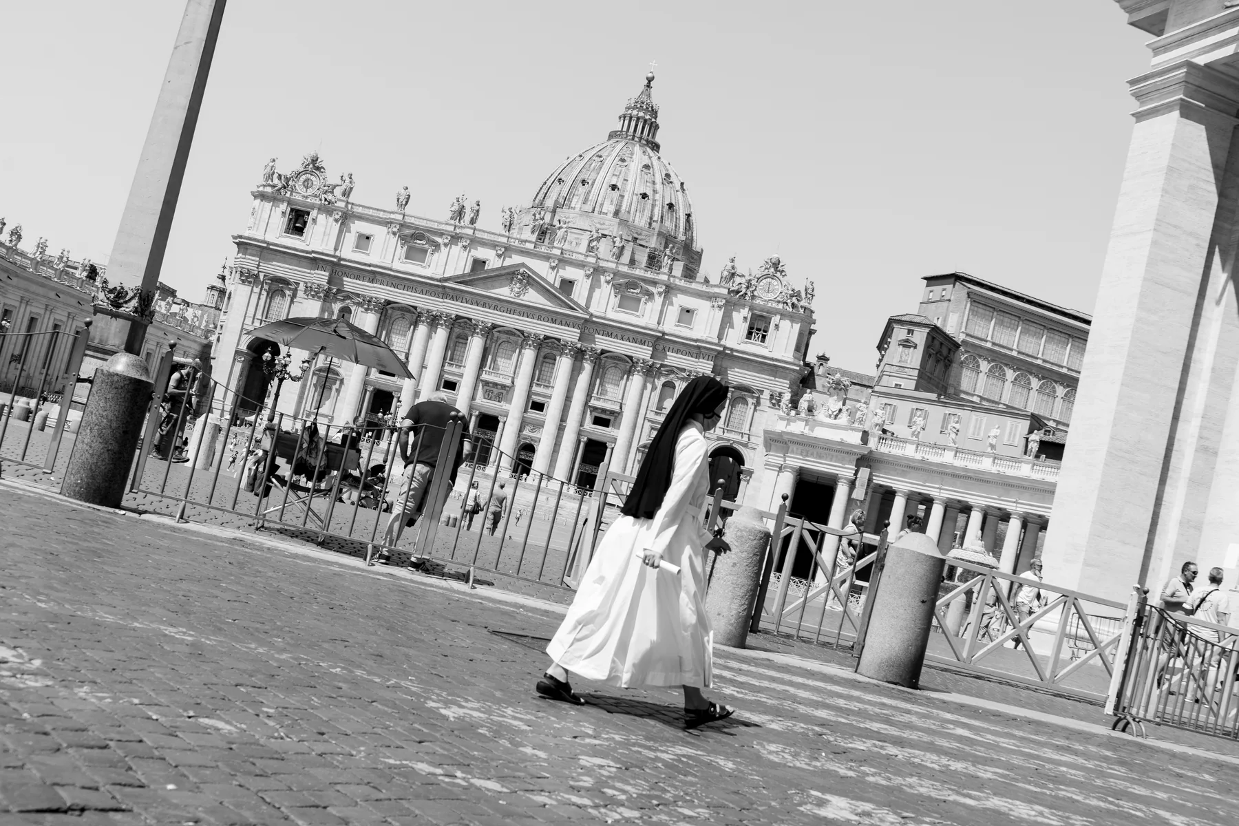 Religiosa attraversa Piazza San Pietro con la Basilica sullo sfondo