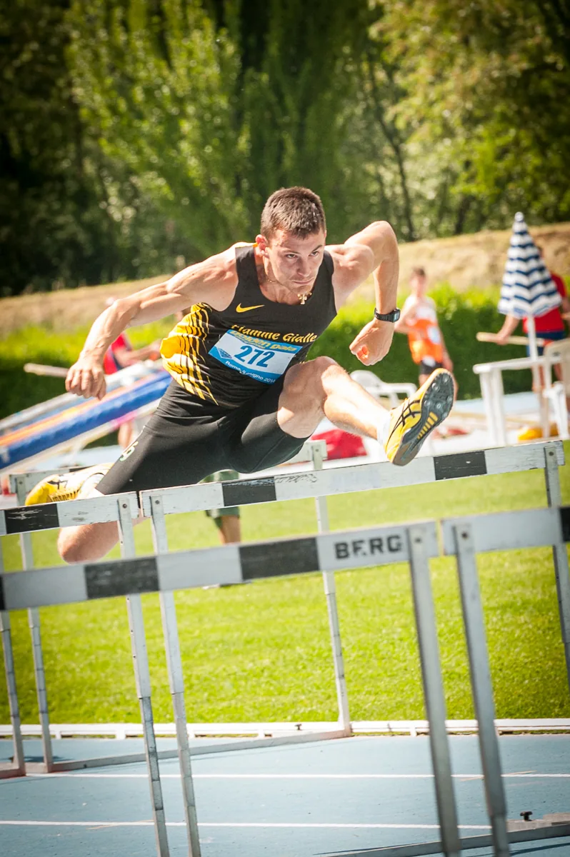 Atleta durante il superamento di un ostacolo in pista