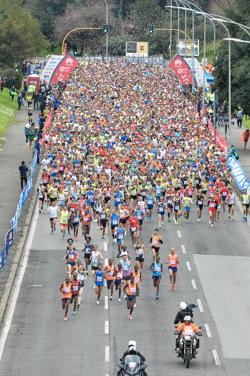 Grande gruppo di runner alla partenza di una gara su strada a Roma